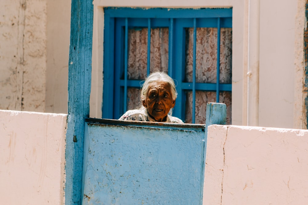 anciana de pie cerca de la puerta cerrada