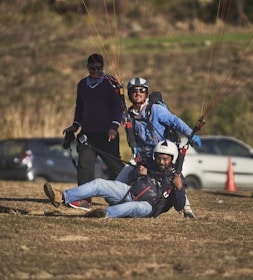 Happy customers preparing for a tandem paragliding flight with an instructor.