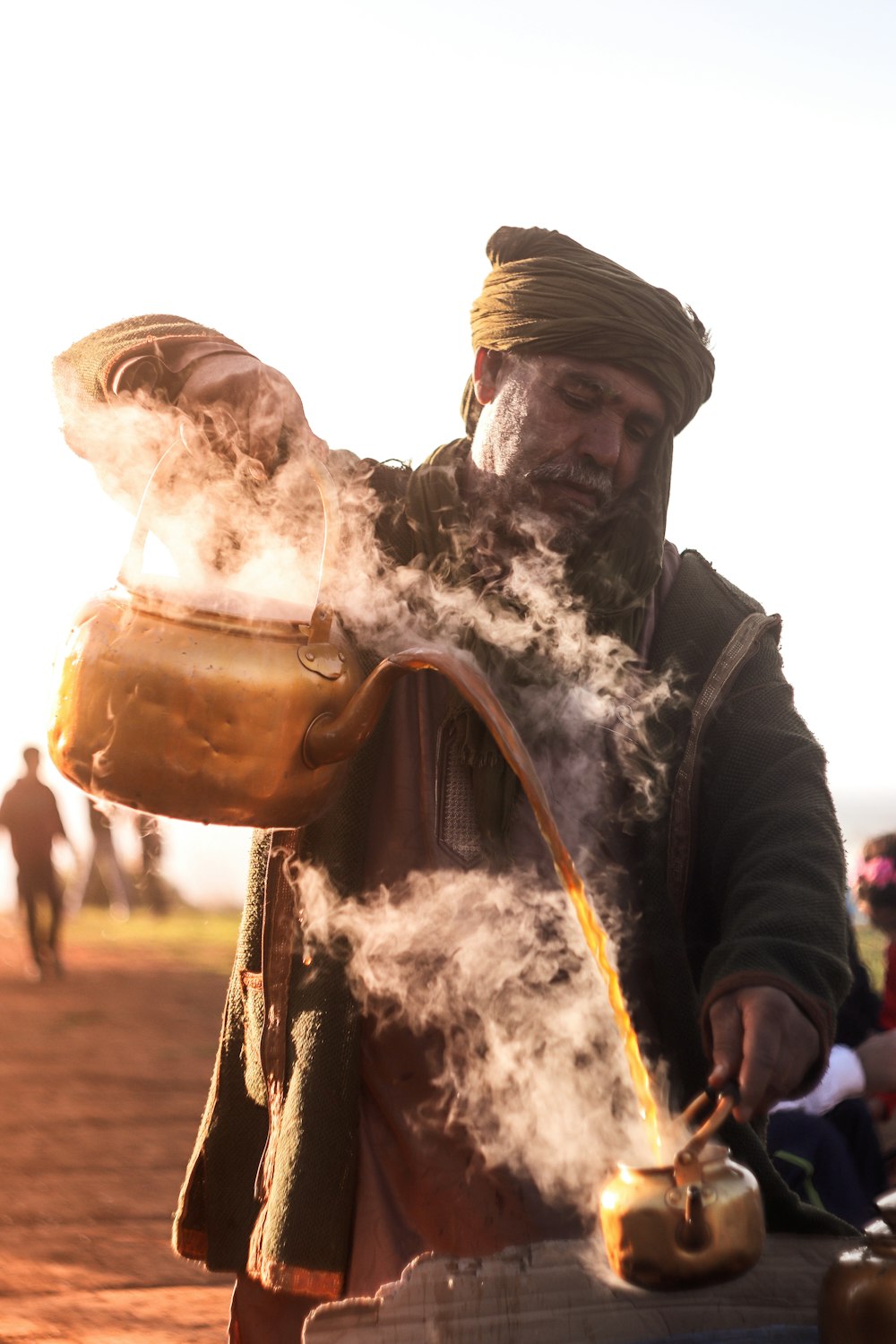 man standing while pouring coffee on another kettle