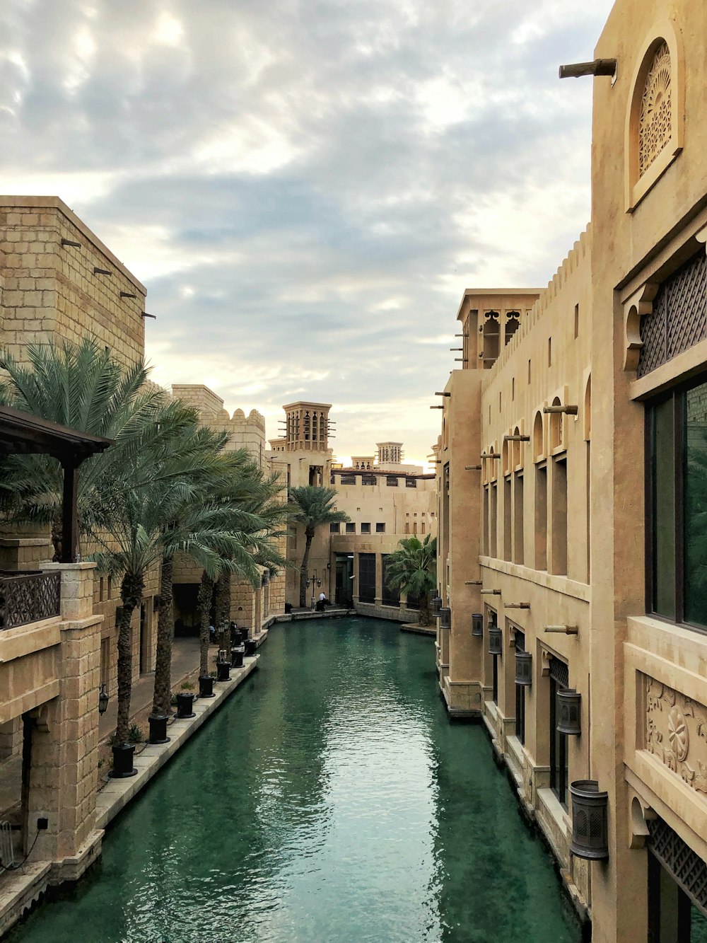 photography of brown building beside body of water during daytime