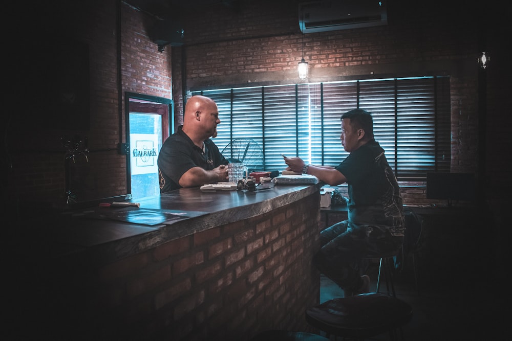 Dos hombres hablando en la zona del bar