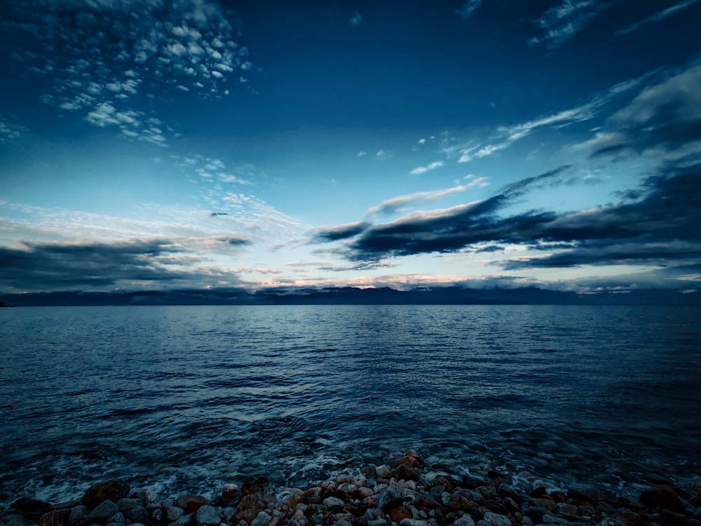 calm sea under blue cloudy sky