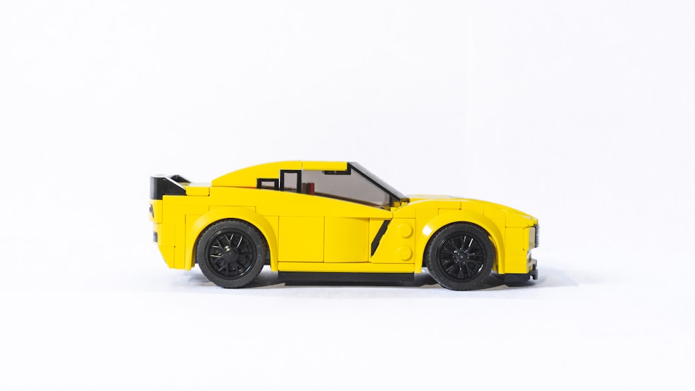 shallow focus photo of yellow coupe die-cast model