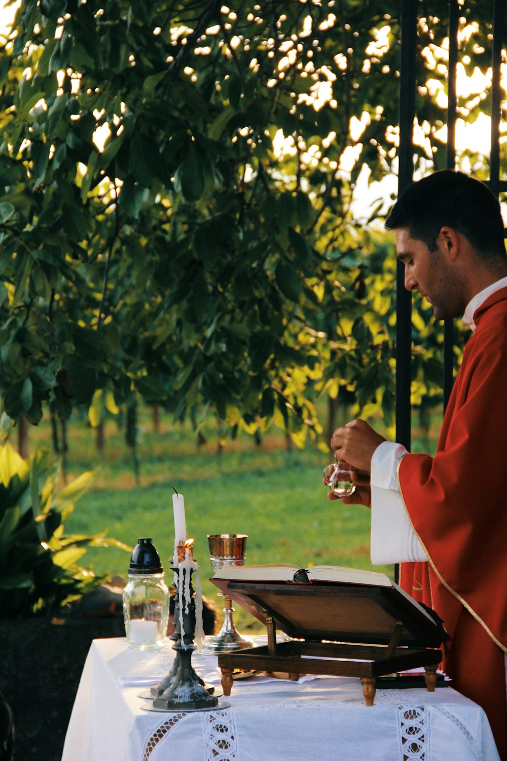 sacerdote sosteniendo una botella frente al altar