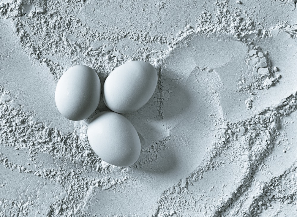 three white eggs on white powder