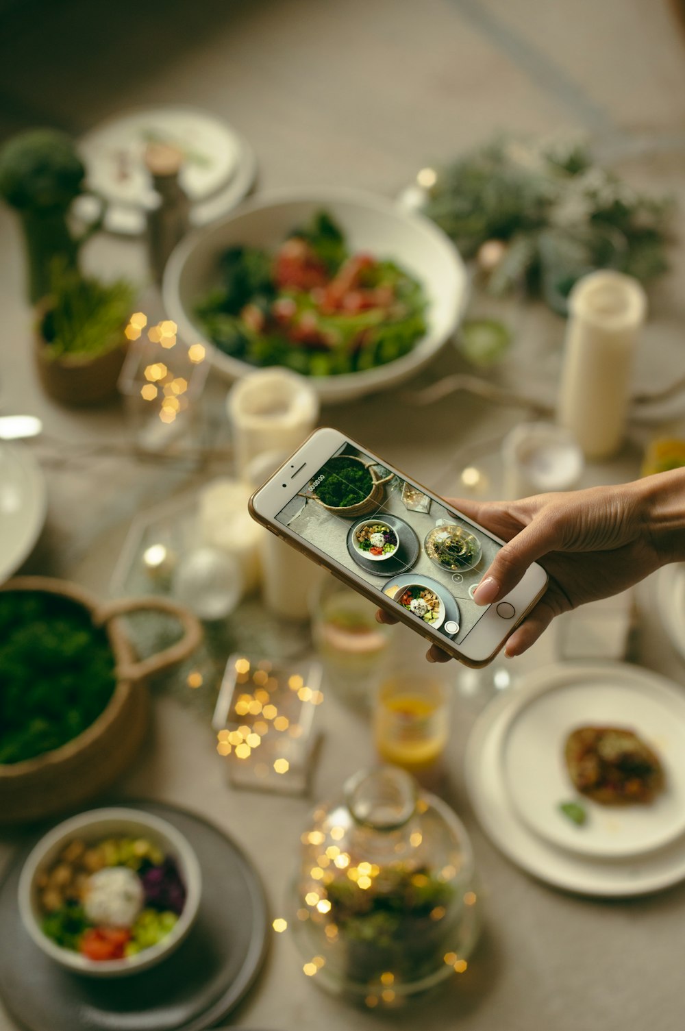 person taking picture of variety of food using phone