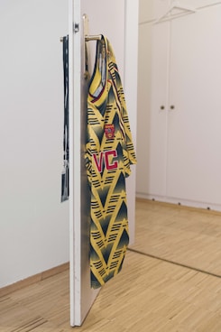 yellow and black shirt hanging on white wooden door