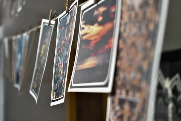 A sequence of freshly developed analog prints drying on a line under soft light.