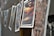 A series of photographs are hanging on a line, secured with wooden clothespins. The images feature various scenes, including landscapes and cityscapes, with vibrant colors and blurry effects. The angle of the shot provides a depth of field, focusing on the middle images while others are out of focus.