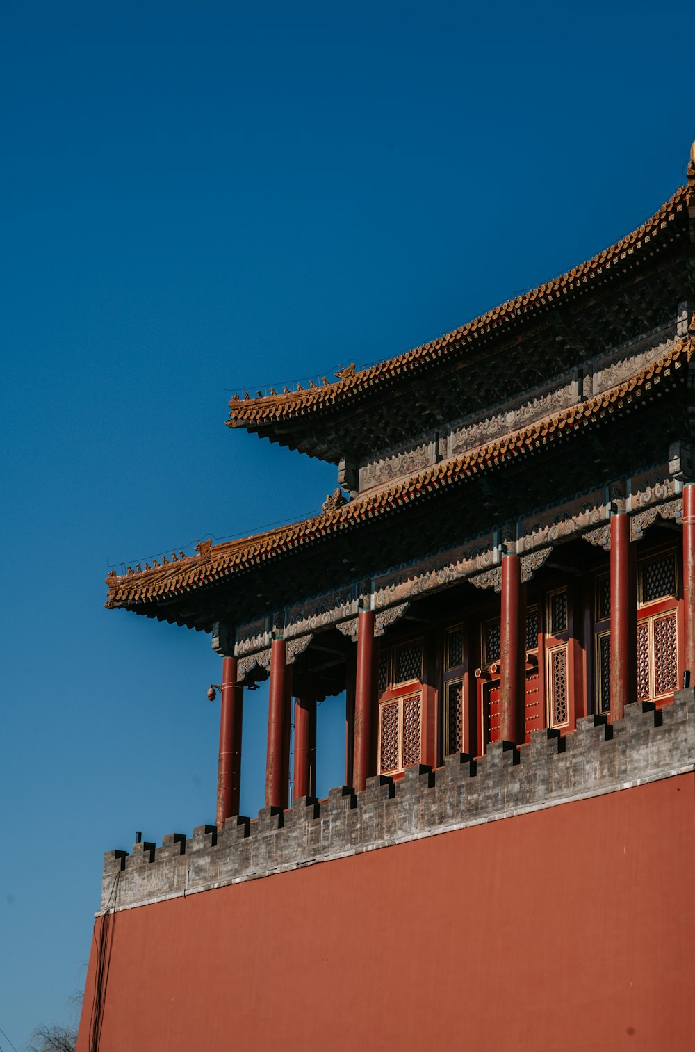 low-angle photography of a red pagoda building under a calm blue sky