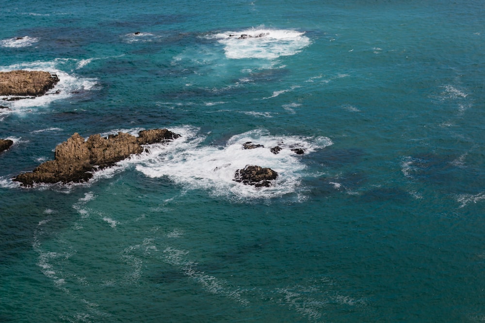 aerial photography of rock formations in the sea