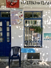 blue armchair and square table placed outside a cafe