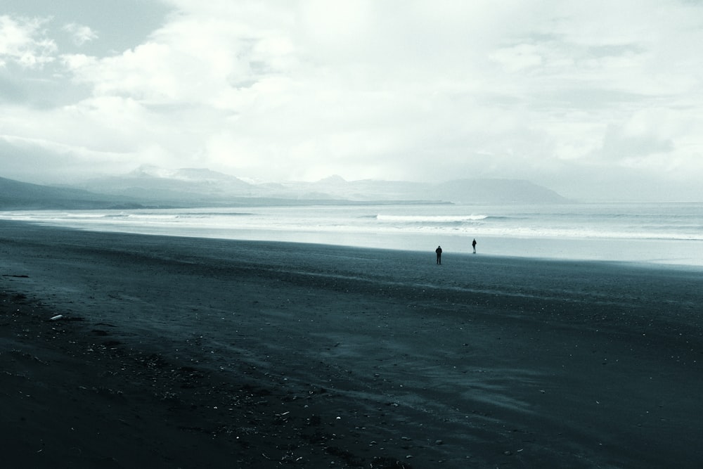 man on shore under cloudy sky