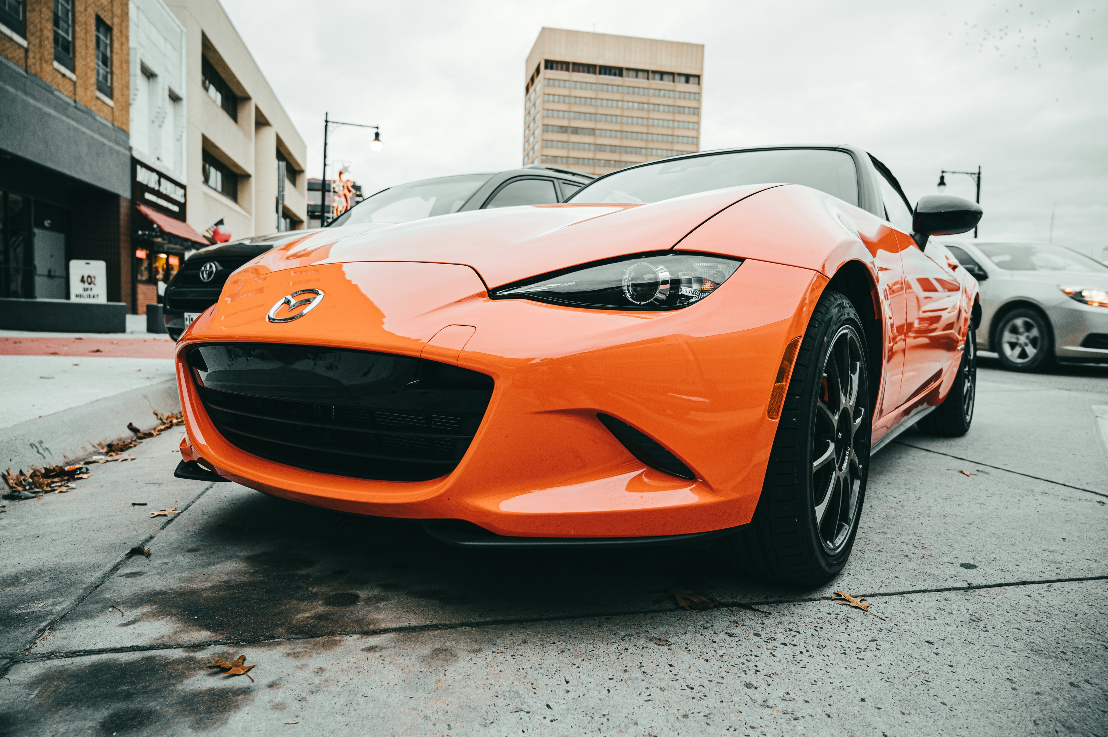 Orange Mazda Coupe Parked Near Another Vehicle Photo Free