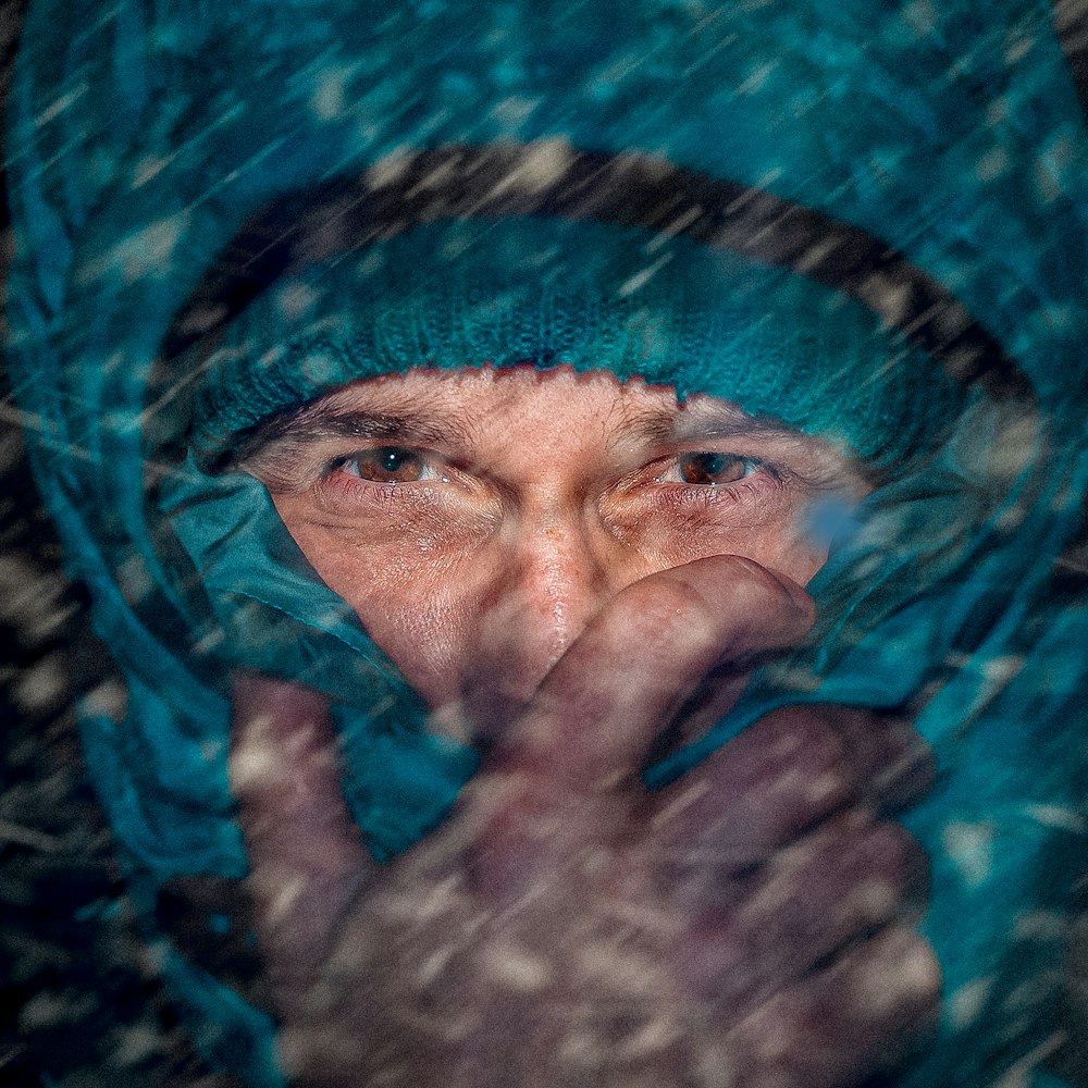 man in teal snow jacket