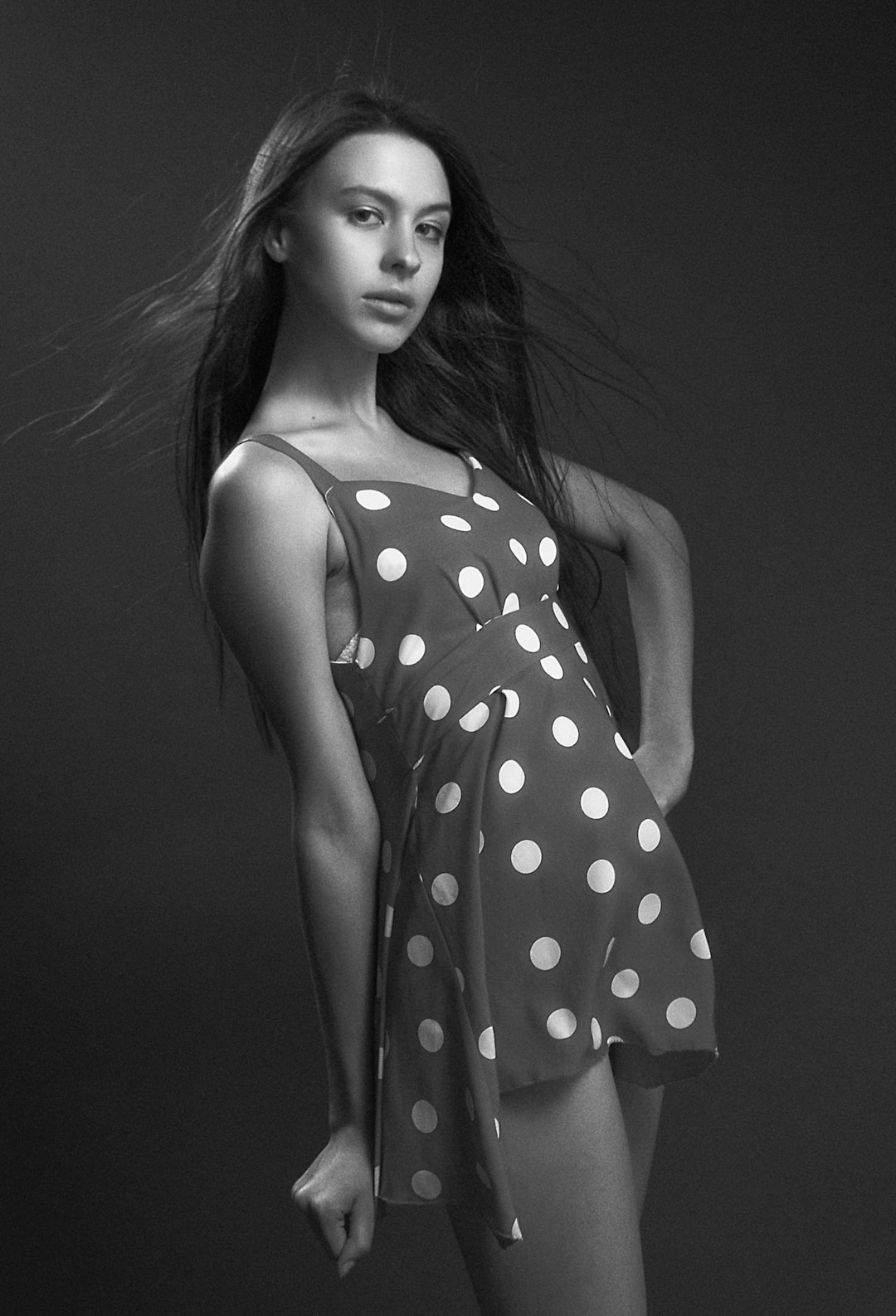 grayscale photography of woman in polka-dot spaghetti strap mini dress