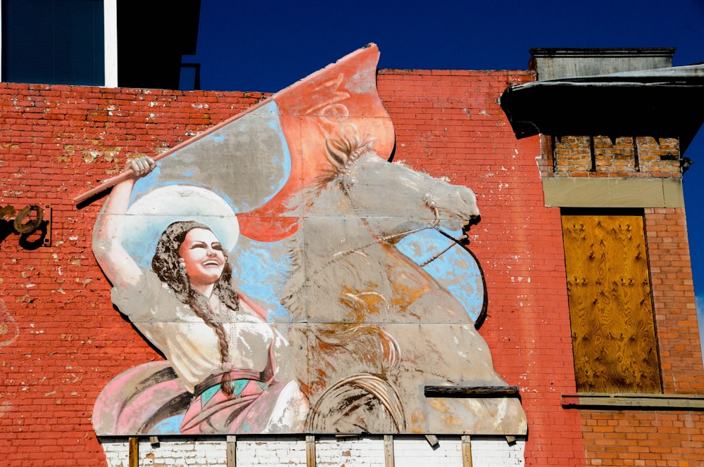 woman riding horse holding red banner graffiti