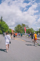 Volunteers handing out water at a community charity run event on a sunny day.
