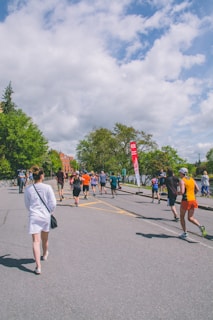 A group of runners sharing a laugh mid-run on a sunlit forest road, sweat and smiles mingling.