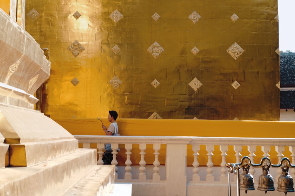 person standing beside gold wall
