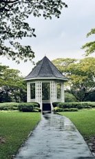 white gazebo between trees