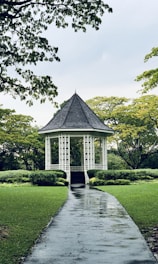 white gazebo between trees