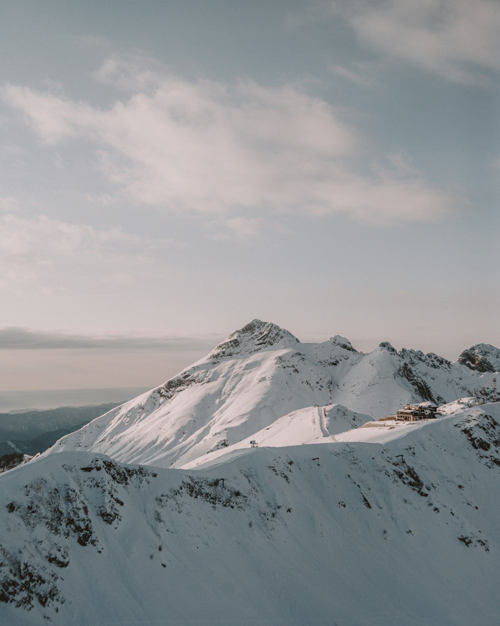 summit of mountain covered with snow under white and blue sky