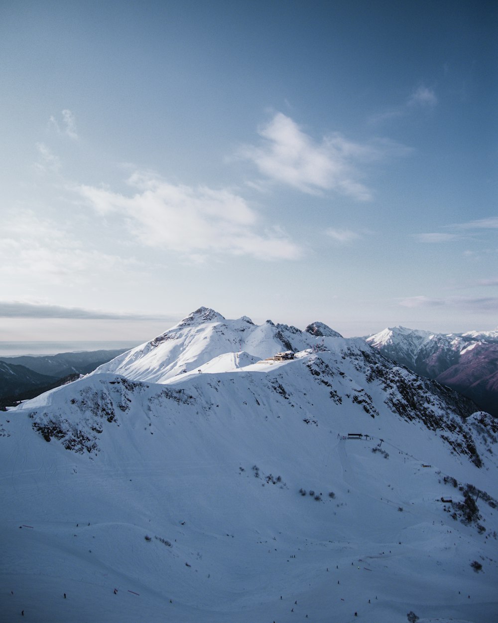 summit of mountain covered with snow under blue and white sky