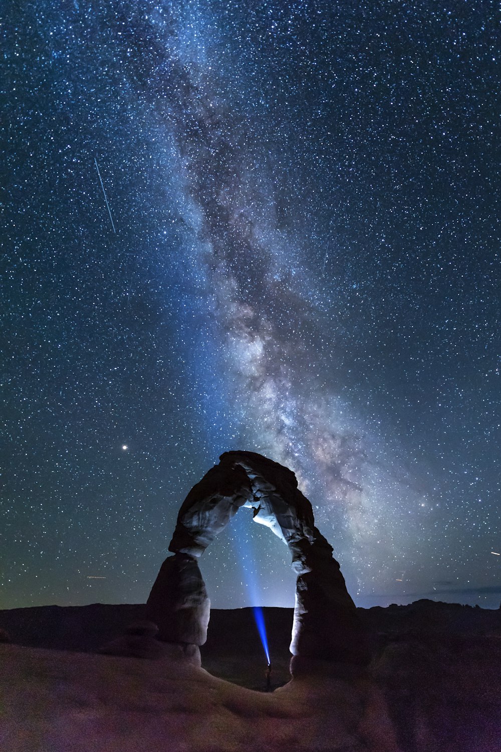 natural arch viewing milky way during night time