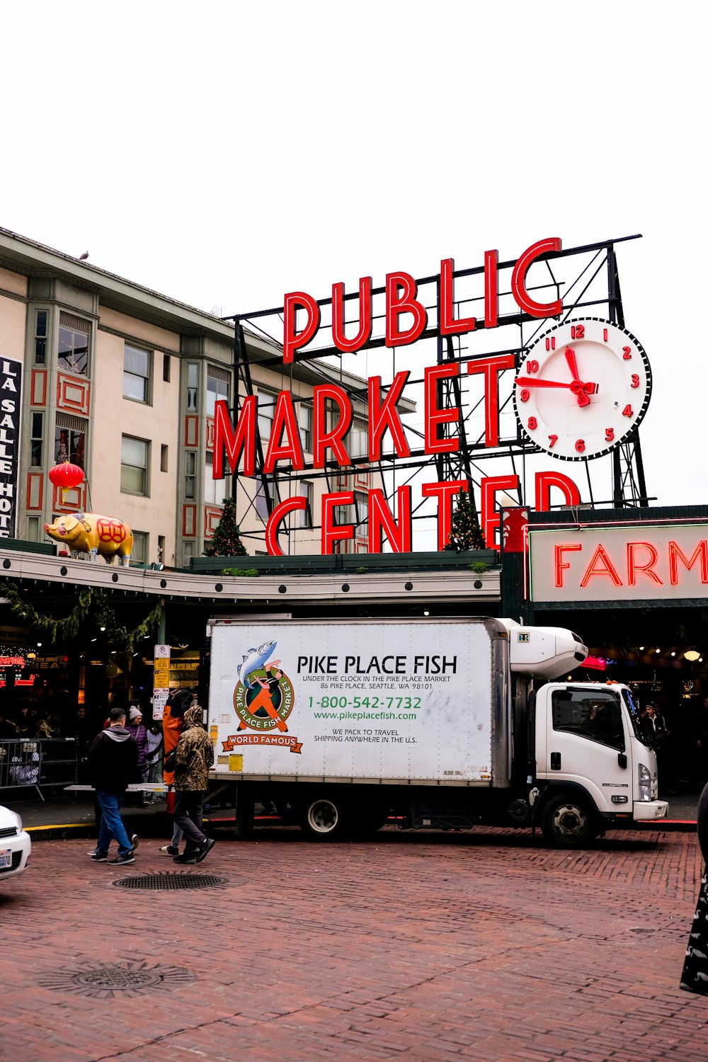 Menschen und Pike Place Fish Luton-LKW tagsüber neben dem Public Market Center geparkt