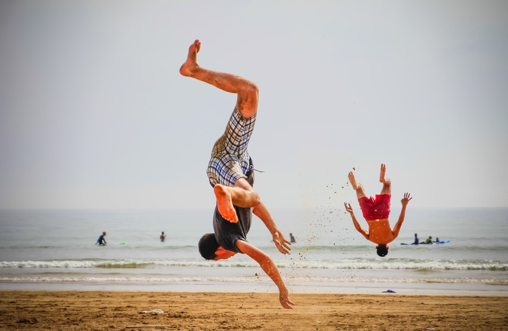two men doing stunts near seashore during daytime