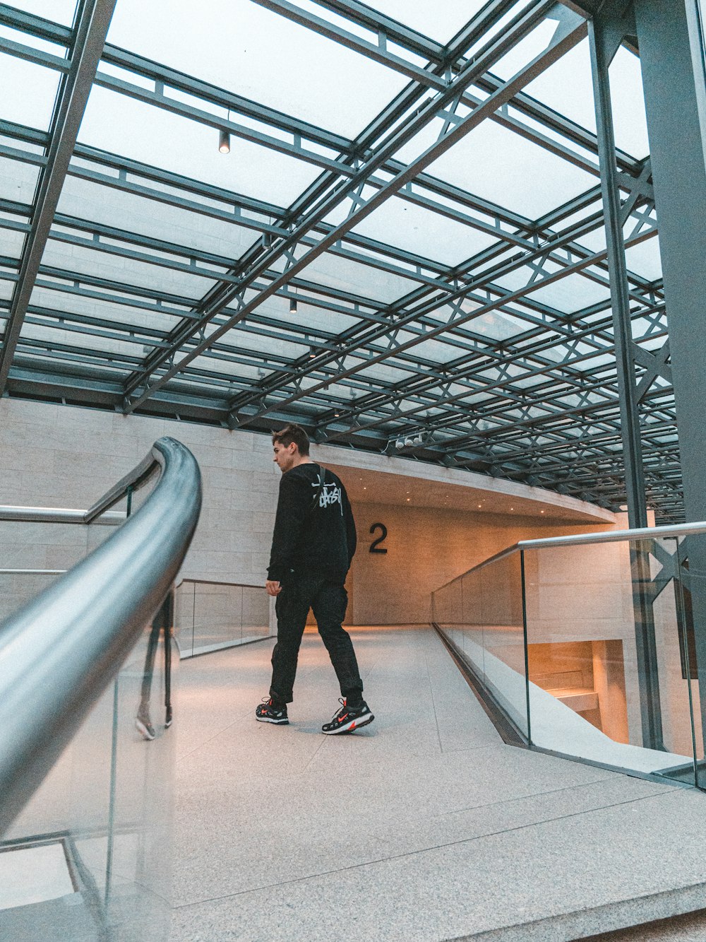 man wearing black and white jacket walking inside building