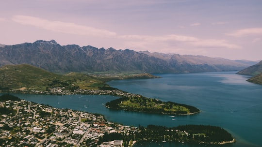 aerial view of city buildings near river during daytime in Skyline Queenstown New Zealand