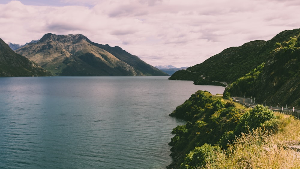 body of water and mountain island during day