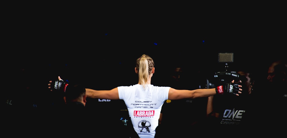 woman wearing white shirt and black grappling gloves