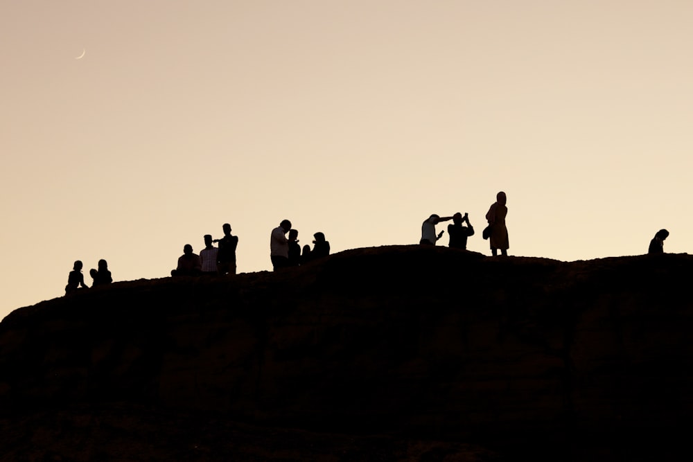 silueteado de personas en la colina durante la noche