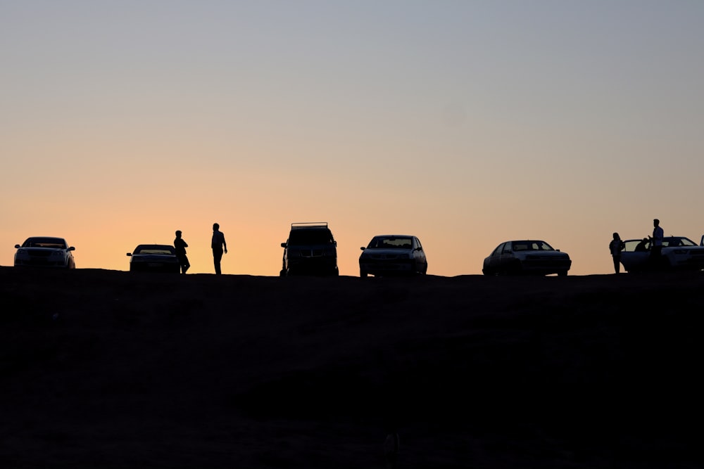 silhouette of people near vehicles