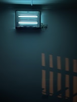 Close-up of a mosquito trap glowing softly in a dark corner of a living room.