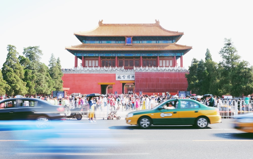 yellow and black sedan running on the road