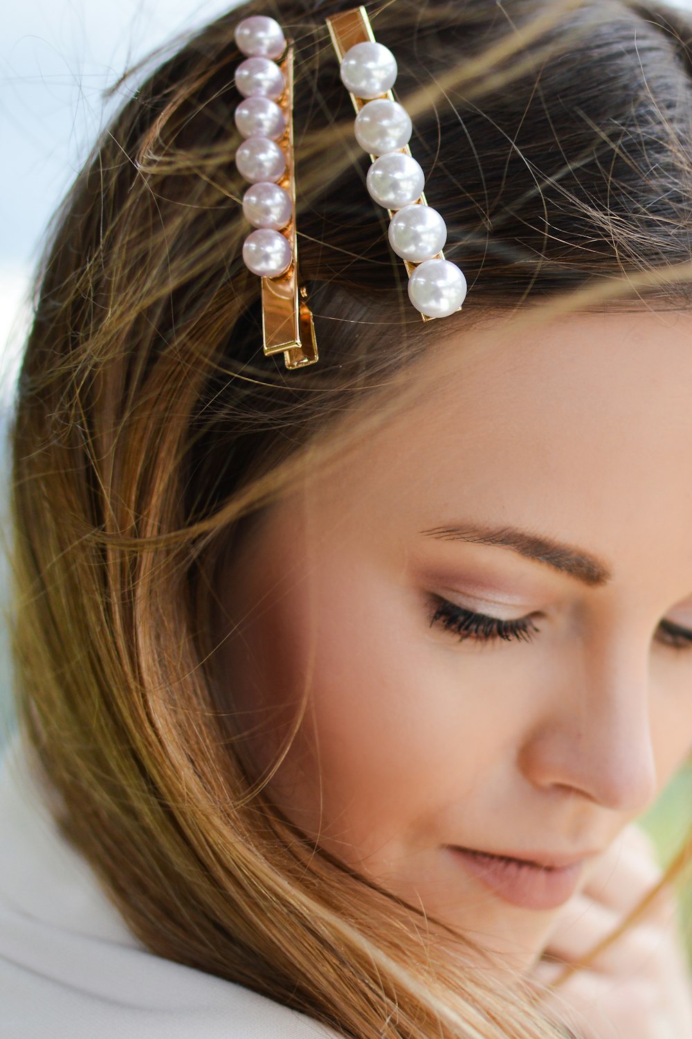 woman with two beaded clips clipped on her hair looking downwards