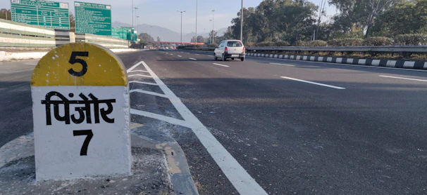 A scenic highway view between Delhi and Rudrapur with a sleek cab on the road.