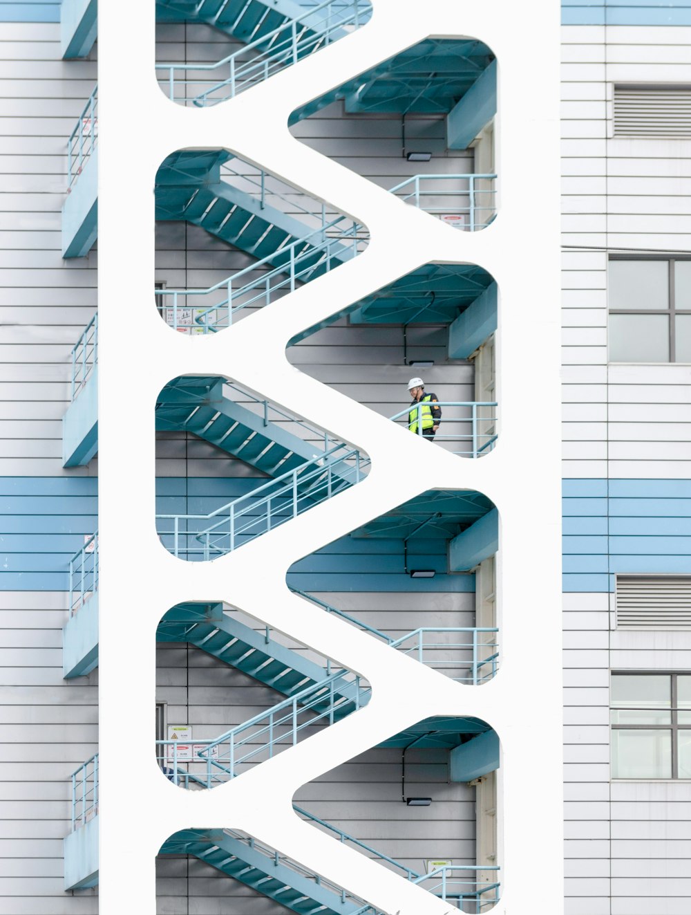 man wearing construction equipment walking down the stairs outside of a building