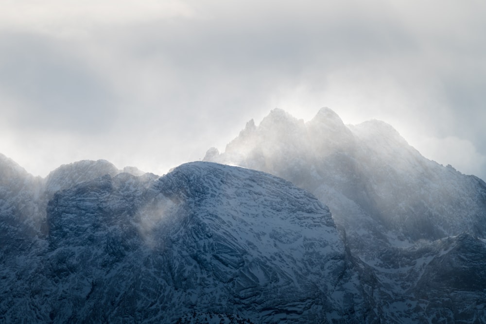 Fotografía aérea de la montaña cubierta de nieve en un día de niebla