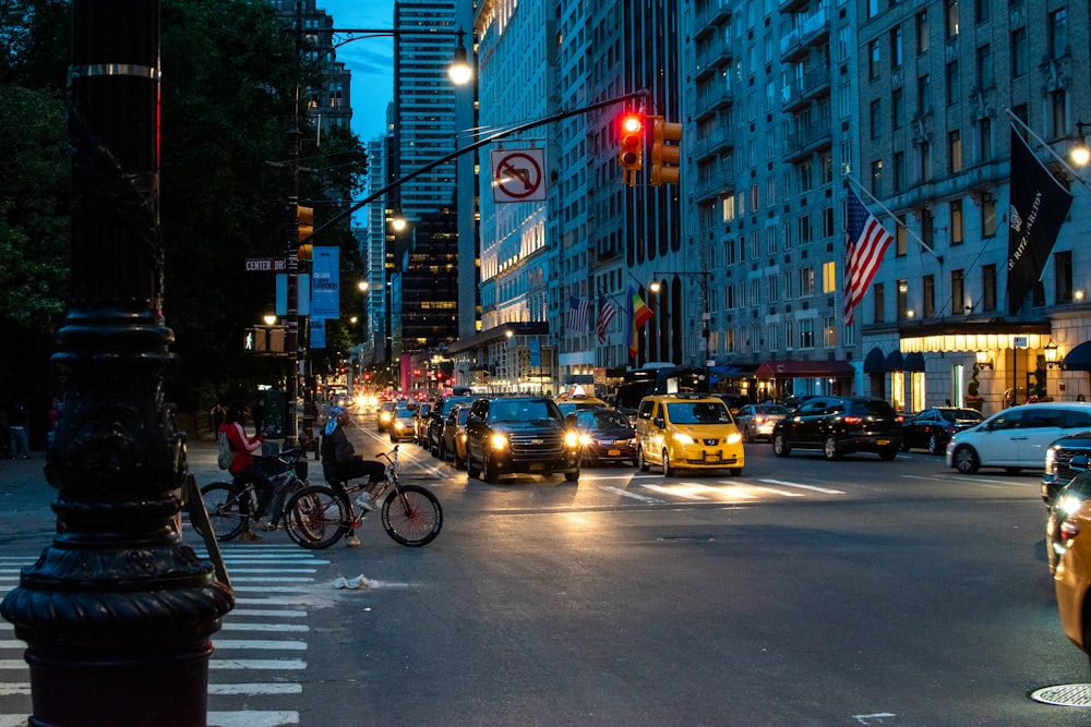 도시 건물 근처의 통로를 걷는 사람들과 야간에는 도로의 다른 차량들