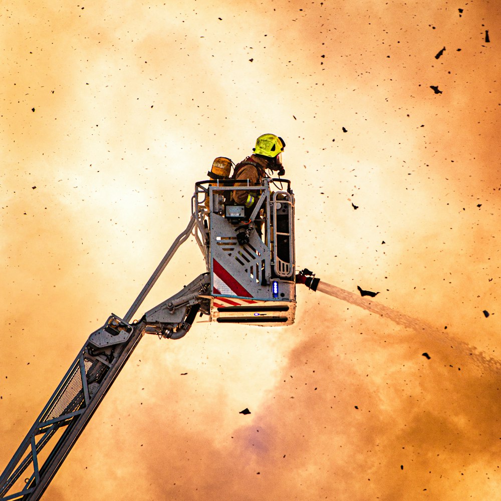 pompier utilisant un tuyau d’incendie sur une grue