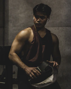 A focused athlete lifting weights in a sleek, dark-toned gym environment.