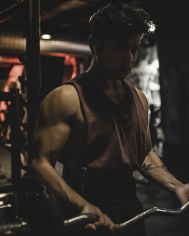A focused individual lifting weights in a minimalist, well-lit gym space.