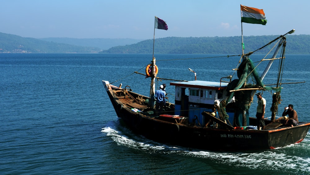 people in brown boat on sea during daytime