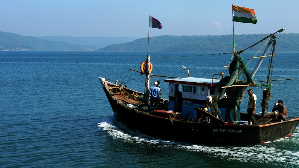 personas en barco marrón en el mar durante el día