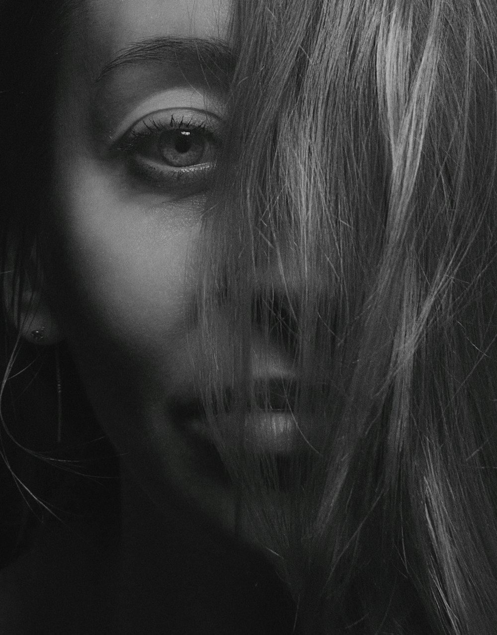 Photographie de portrait de femme couvrant la moitié du visage à l’aide de ses cheveux